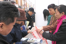 中國質(zhì)量檢驗(yàn)協(xié)會工作人員在2006年“3.15”咨詢活動現(xiàn)場向消費(fèi)者發(fā)放資料